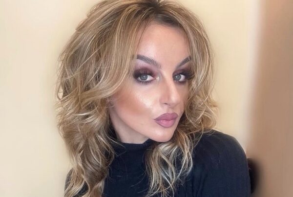 Woman with long, layered blonde hair in soft waves, styled with professional hair extensions at Davida Salon in NYC.